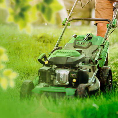 man cutting the grass in backyard garden using lawn mower and professional gardening tools